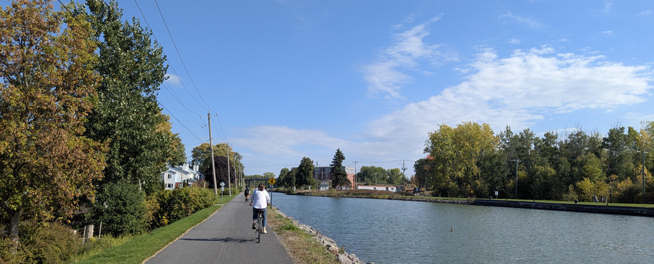 01Web story_QC_Lieu-historique-national-du-Canal-de-Chambly_credit Bich-Anh Nguyen_support image | Trans Canada Trail person biking on a paved bike trail on a sunny day, port side