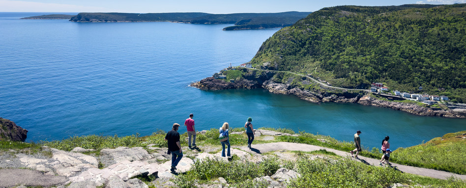 NL - St Johns - East Coast Trail - Signal Hill | Trans Canada Trail people hiking on a trail overlooking mountains and sea below