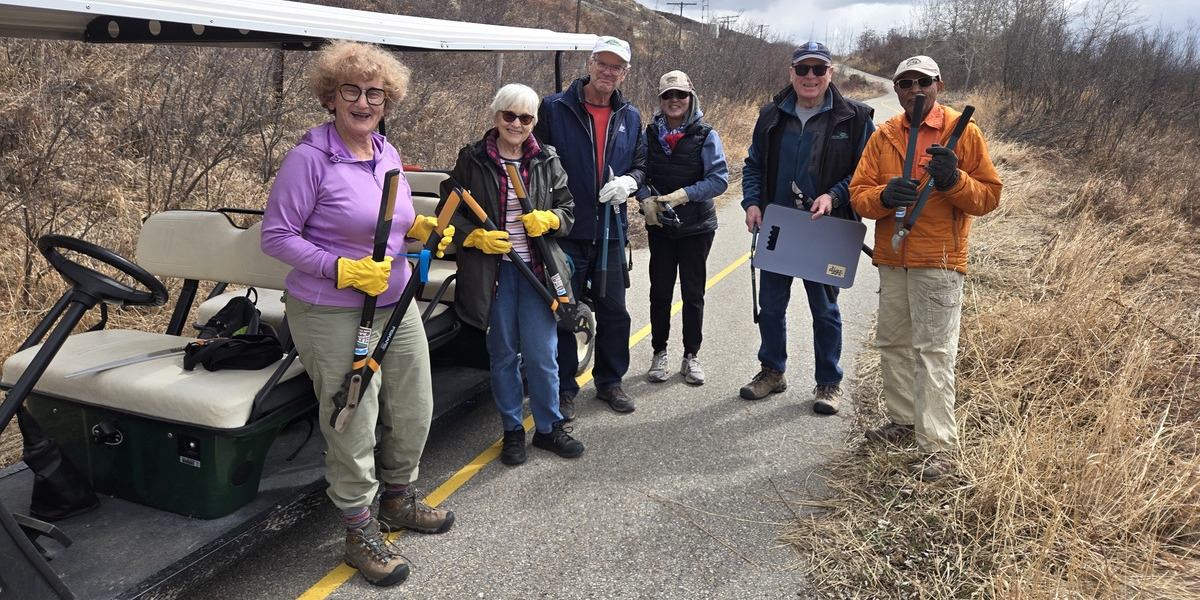 00Feature image_SF107815_AB_Trail-Care-2025-Glenbow-Ranch-Park-Foundation | Trans Canada Trail people smiling holding hedge trimmers on a paved road