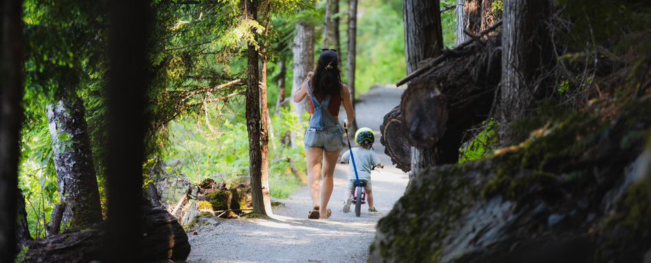 BC - Sea to Sky Trail Pemberton Photo Credit Brent Harrewyn | Trans Canada Trail woman and child walking along a wooden trail on a sunny day