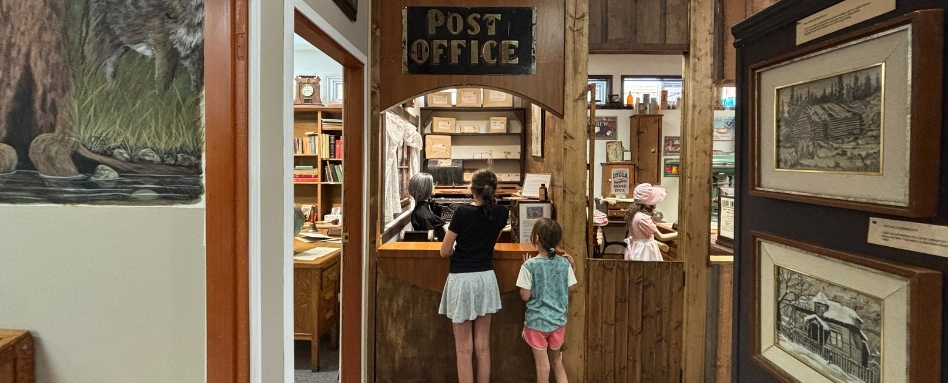 two children standing in a museum post office