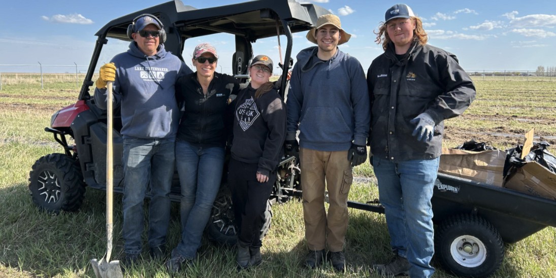group of people standing infront of cart holding tree planting gear on a sunny day