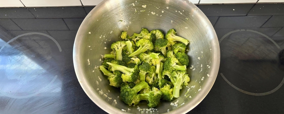 02Support image_roasted broccoli_mix | Sentier Transcanadien A metal mixing bowl with pieces of broccoli and minced garlic.