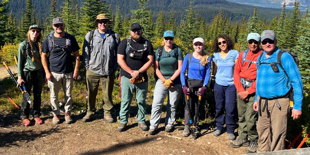 00Feature image_AB_107672-Friends of Kananaskis_web story | Trans Canada Trail group of people in hiking gear standing on mountain on a sunny day