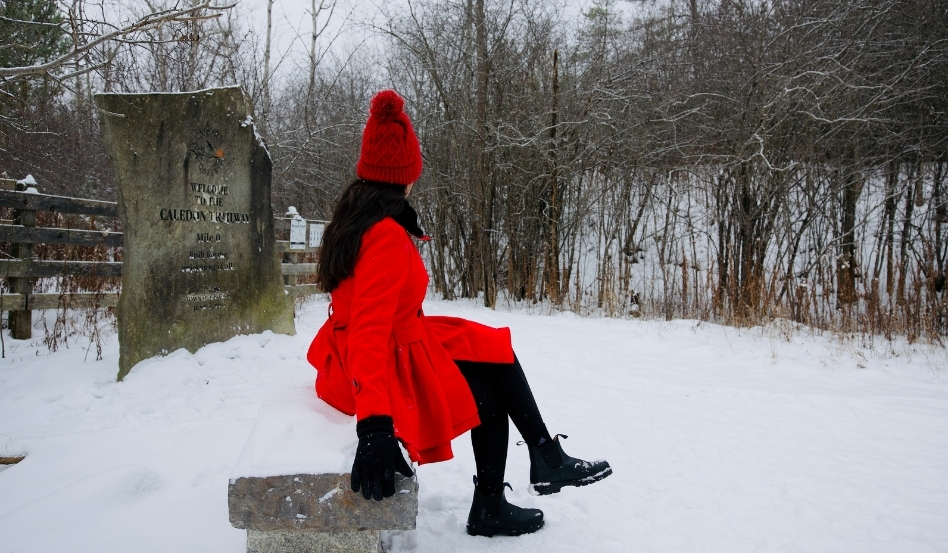 01Support image_ON_Caledon Trailway_credit Travels with Asavari | Trans Canada Trail woman sitting on a rock in the snow