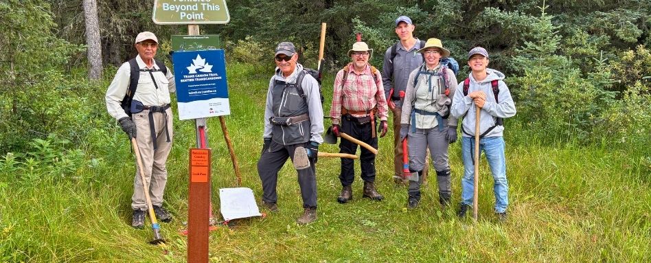 03Support_AB_107672-Friends of Kananaskis_web story_group with sign | Trans Canada Trail people with shovels and hiking gear smiling