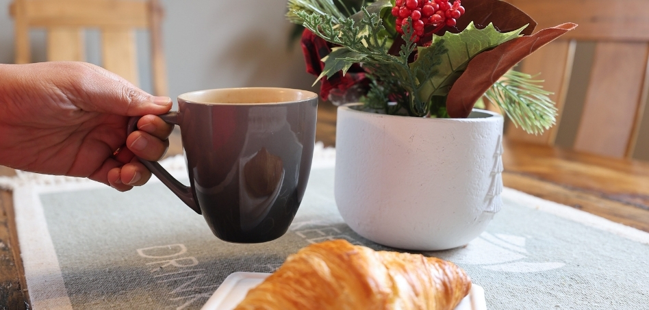 04Support image_ON_Caledon Trailway_credit Travels with Asavari | Trans Canada Trail person holding a coffee cup with croissant on table