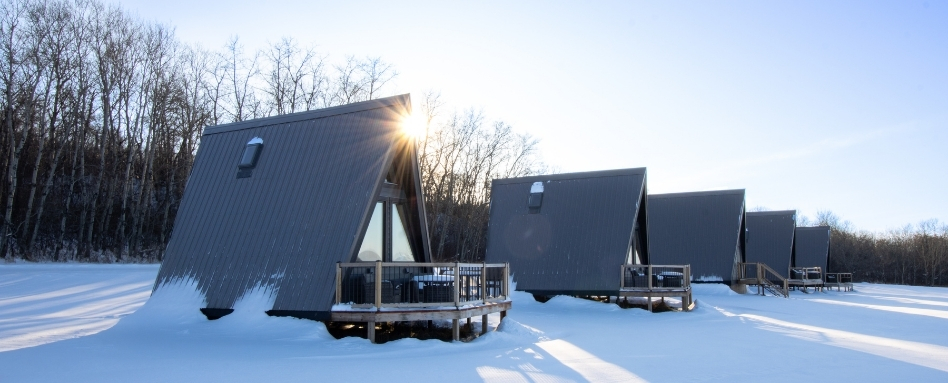 06SK_Pemiska_Support image_chalets_credit Pemiska Tourism | Trans Canada Trail A row of A-frame cottages on a snowy, sunny day