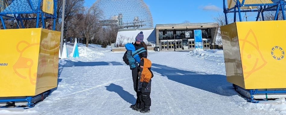 woman and children in snow gear on a snowy skating trail on a sunny day