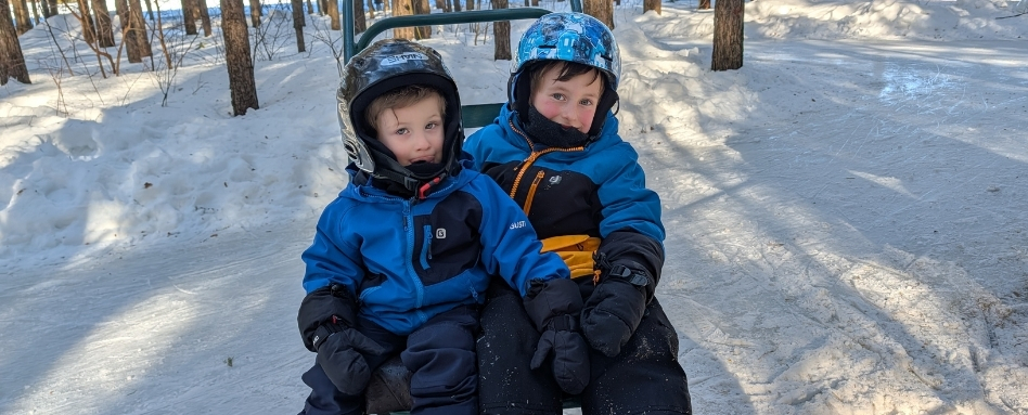 two boys in snow gear posing for a photo
