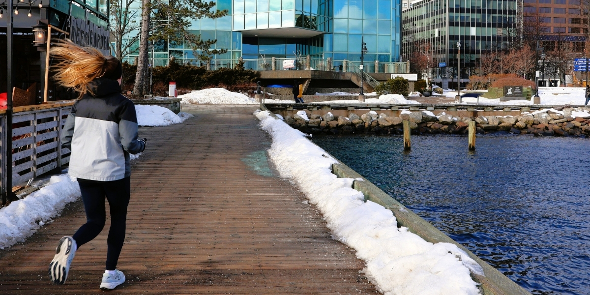 person running on boardwalk on snowy day