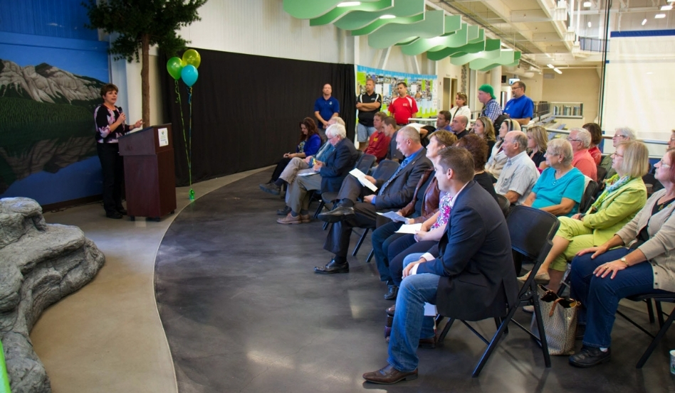 people sitting in a conference room with balloons surrounding