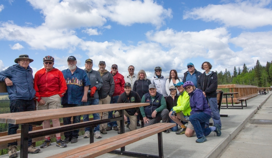 group of people standing at an outlook point with picnic table