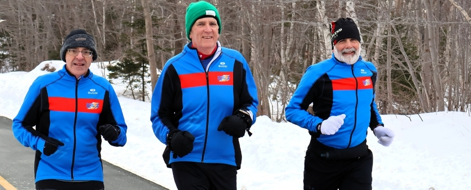 people running as a group on a snowy forest trail