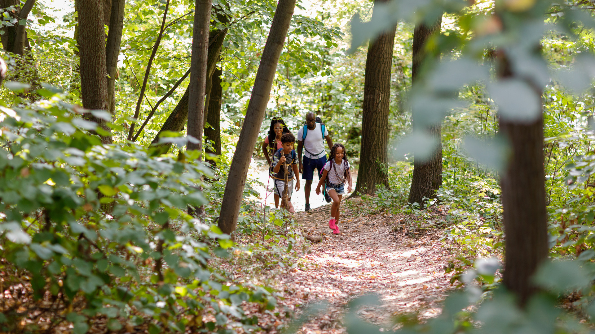 A family walking together through the woods.