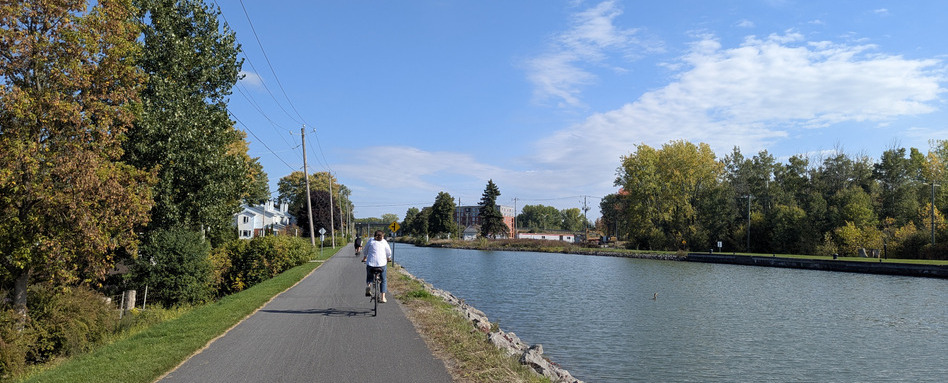 person biking along waterfront trail on a sunny day