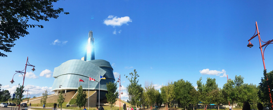 large building on a sunny day with forest behind