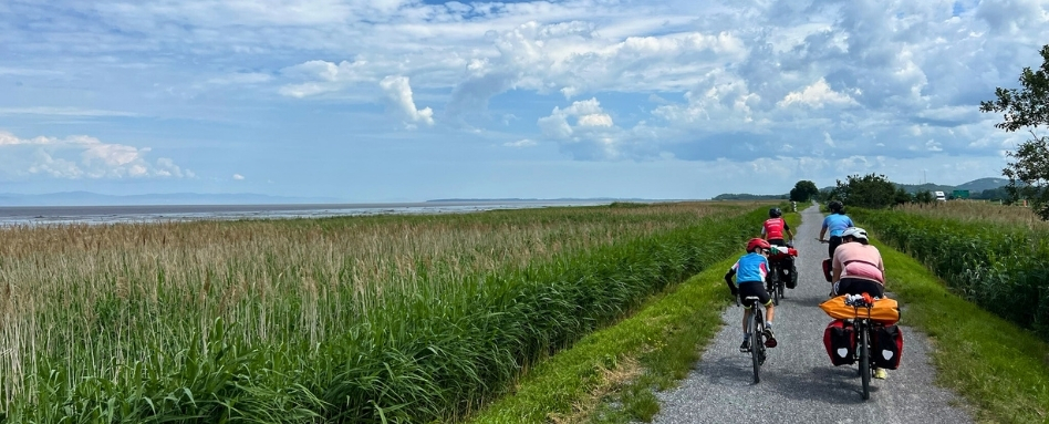family cycling along gravel trail in a field