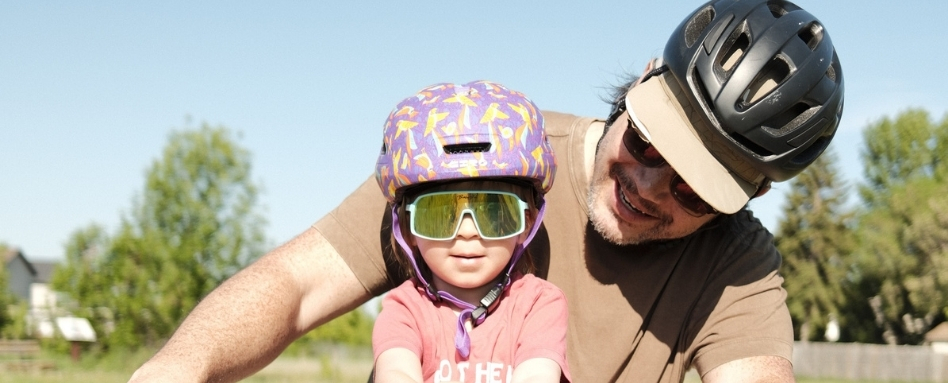 man and child smiling on a bike ride