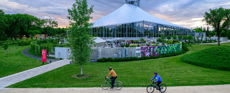 large greenspace building with cyclists in front