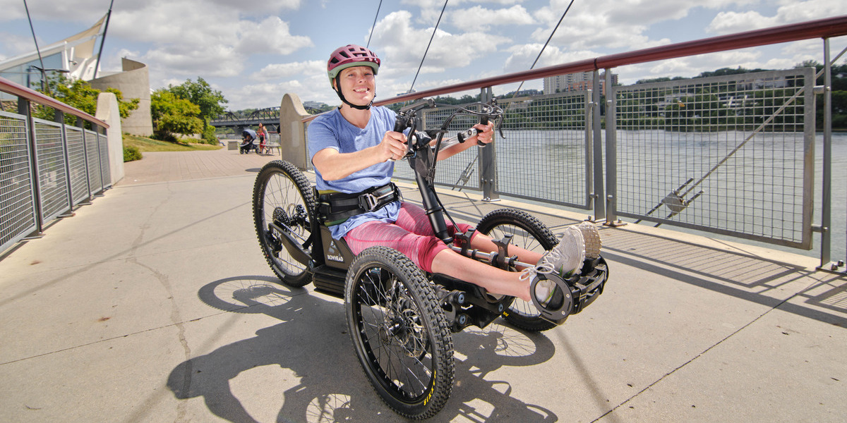 00Feature image_GCH Prairies_Meewasin-Trail_River-Landing_ | Trans Canada Trail woman in wheelchair smiling on a paved over water trail