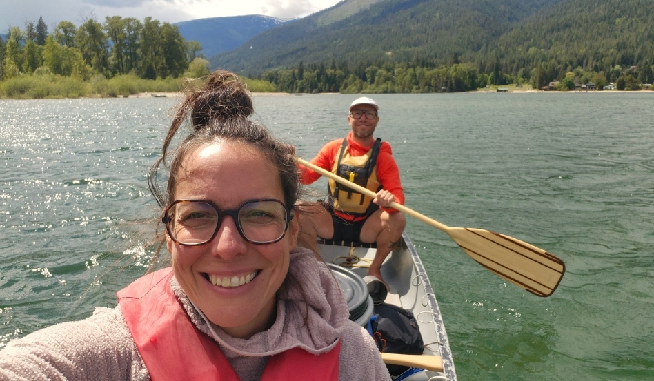 03Support image_Ali Becker West Arm Paddle Route web story_credit Ali Becker | Trans Canada Trail two people taking a selfie in a canoe on water with mountains behind