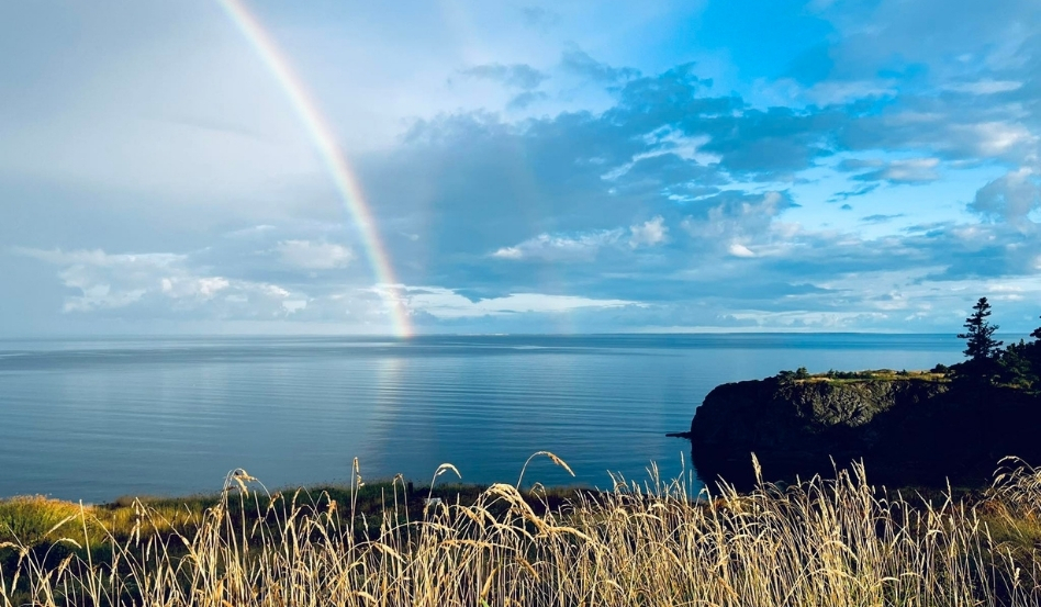 rainbow over waterfront at dusk