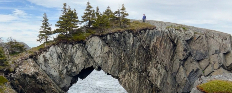 03Support image_NL_East Coast Trail Berry Head Arch_credit Taryn Eyton | Trans Canada Trail A hiker on top of Berry Head Arch, a large rock formation in Newfoundland