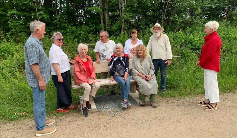 03Support image_NS_Lost Soles on bench_credit Lost Soles | Sentier Transcanadien A group of people sitting on a bench or standing around the bench, smiling