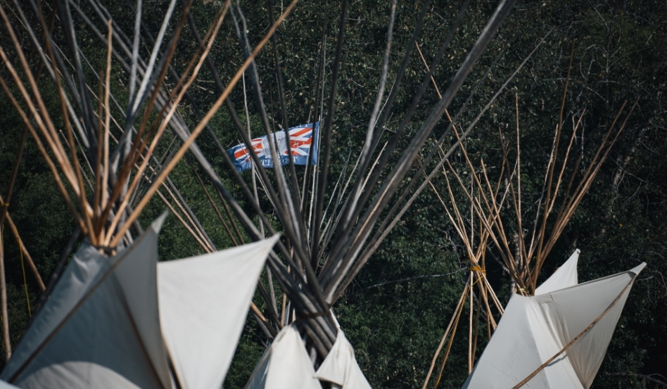 Tipis with a flag in the background